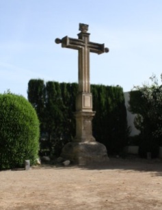 Cruz de piedra frente a la entrada de la antigua capilla del Hotel La Marquesa.